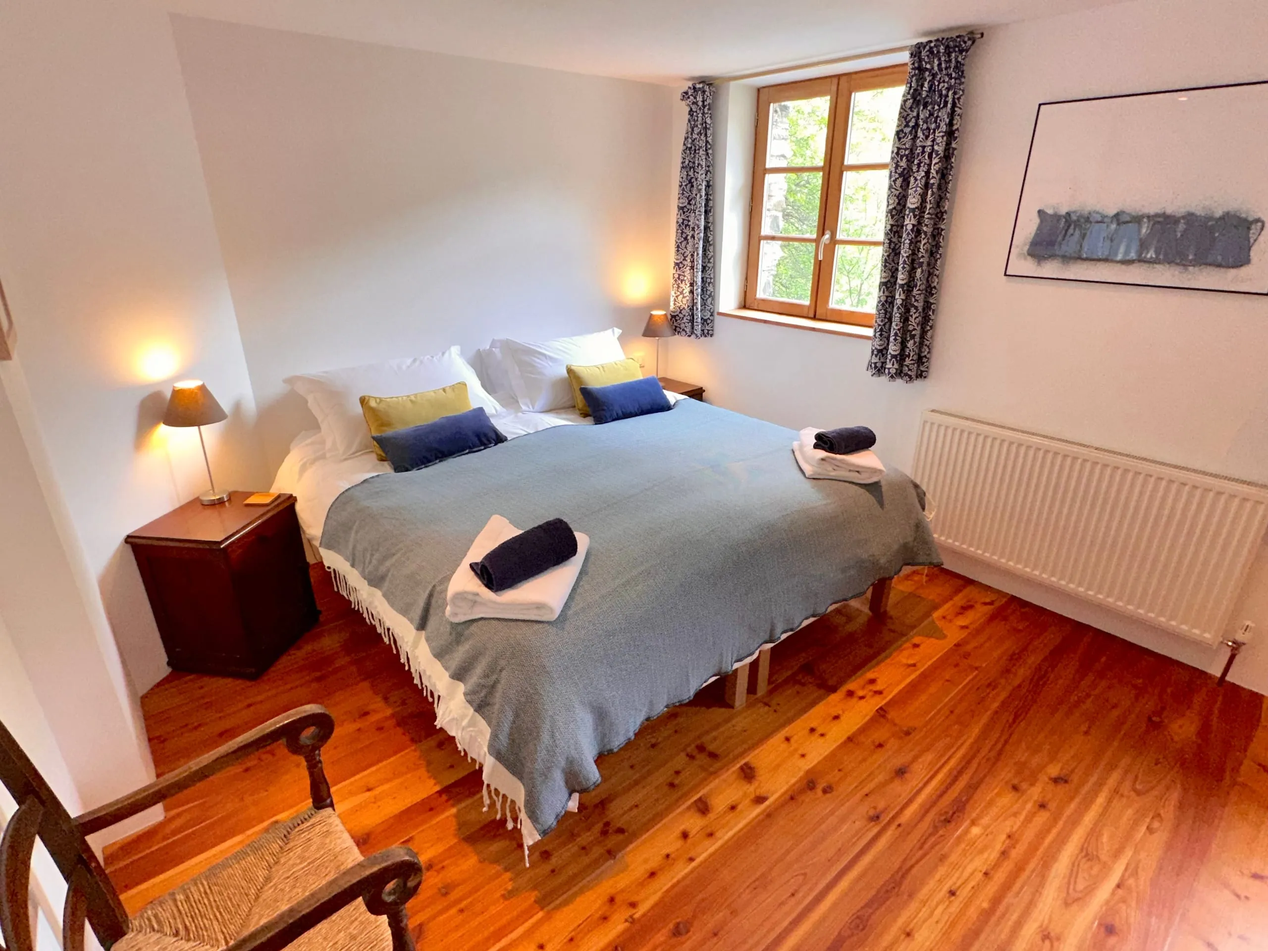 Bedroom four, with a large bed and a window onto the trees