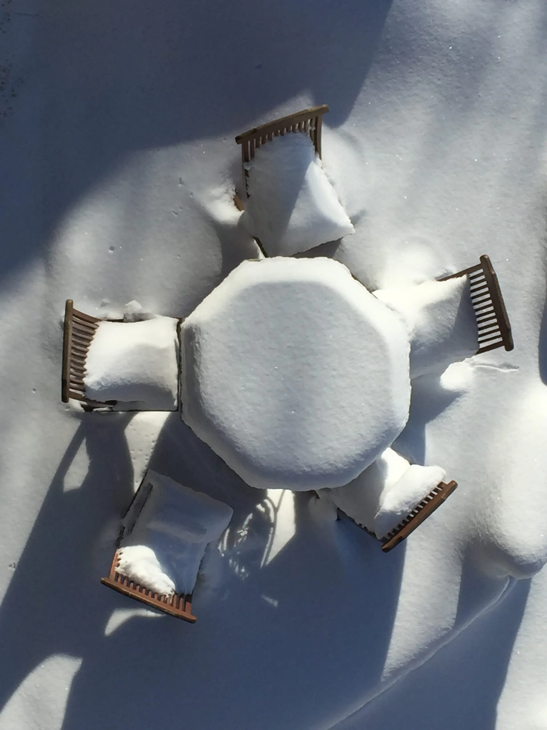 A table and chairs on the terrace, buried in snow
